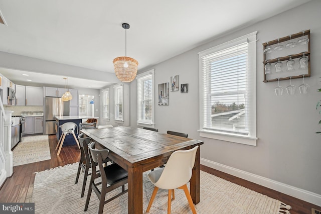 dining space featuring baseboards and dark wood-type flooring