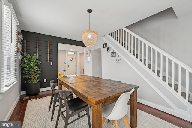 dining space featuring stairway, baseboards, and hardwood / wood-style flooring