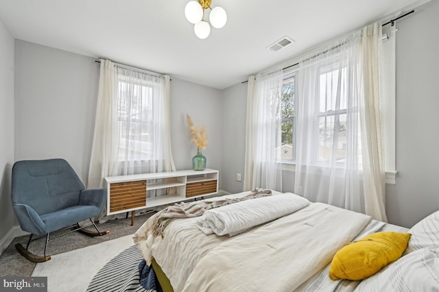 carpeted bedroom featuring visible vents and baseboards