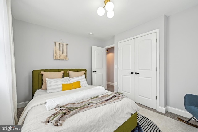 carpeted bedroom featuring a closet and baseboards