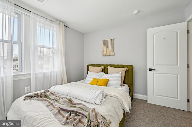 carpeted bedroom featuring baseboards