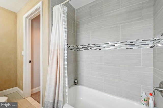 bathroom with tile patterned floors, shower / bath combination with curtain, and baseboards