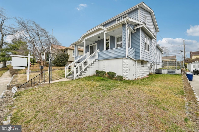 view of front of home with stairway, central AC unit, a porch, and a front yard