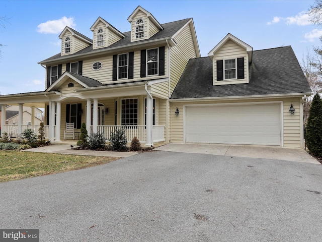 view of front of home featuring a porch, a garage, driveway, and a shingled roof