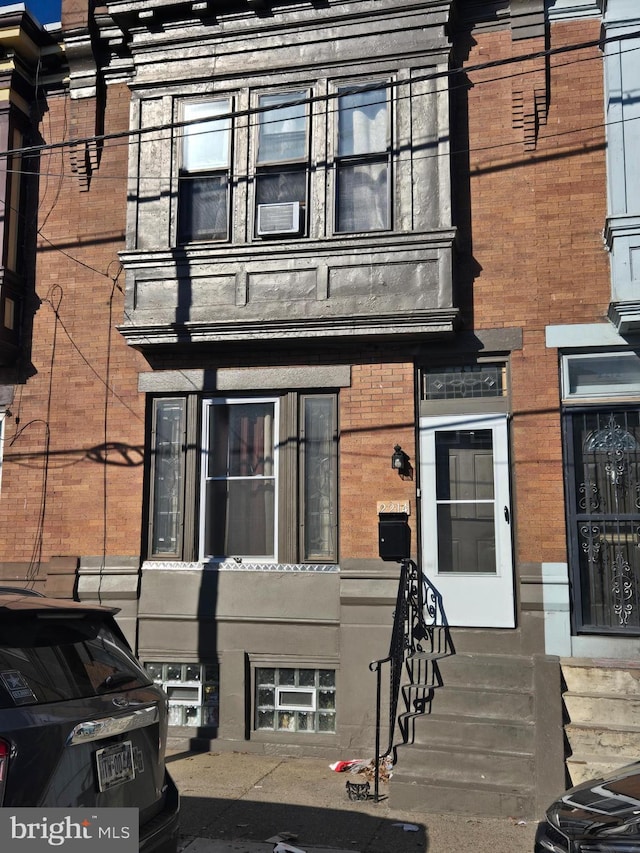 view of exterior entry featuring brick siding