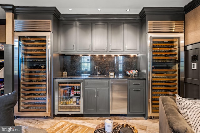 bar with indoor wet bar, wine cooler, a sink, and stainless steel refrigerator