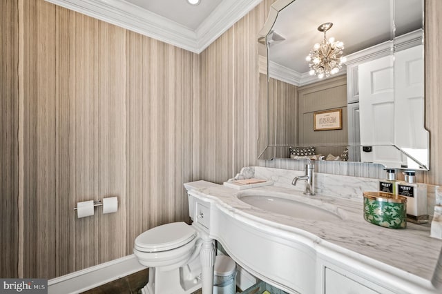 half bath featuring toilet, a chandelier, vanity, and crown molding