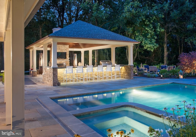 pool with a patio, a gazebo, an in ground hot tub, and exterior bar