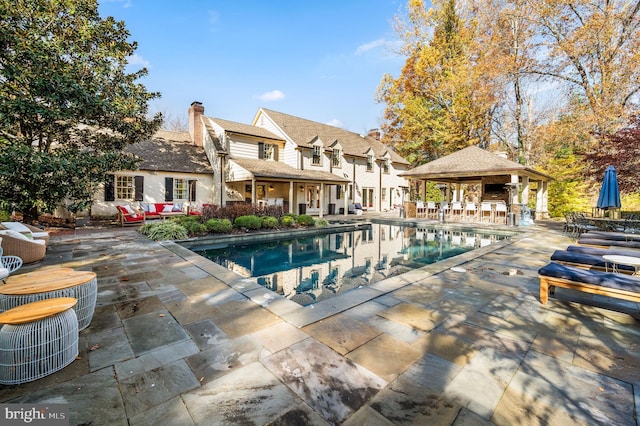 pool with a gazebo and a patio area