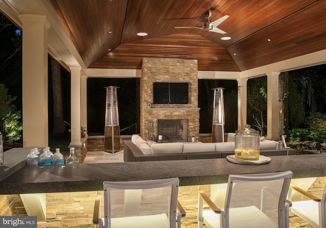 view of patio with an outdoor living space with a fireplace and a ceiling fan