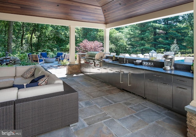 view of patio with an outdoor kitchen, a sink, a gazebo, grilling area, and an outdoor hangout area