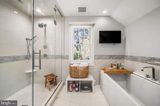 full bathroom with a shower stall, a garden tub, tile walls, and visible vents