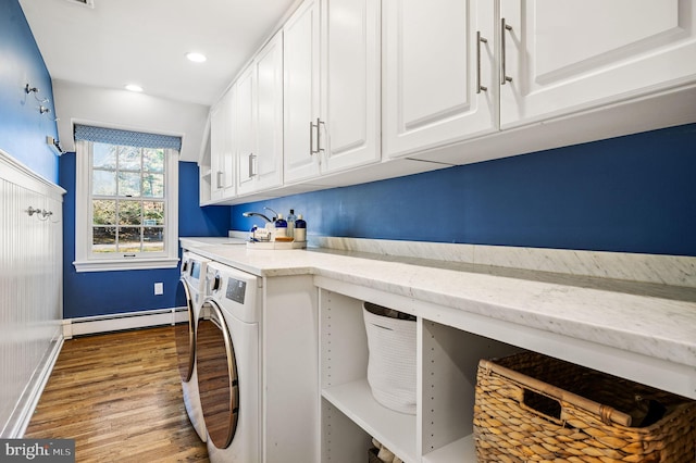 laundry room featuring wood finished floors, baseboards, cabinet space, independent washer and dryer, and baseboard heating