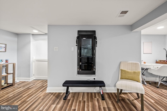 living area featuring visible vents, recessed lighting, baseboards, and wood finished floors