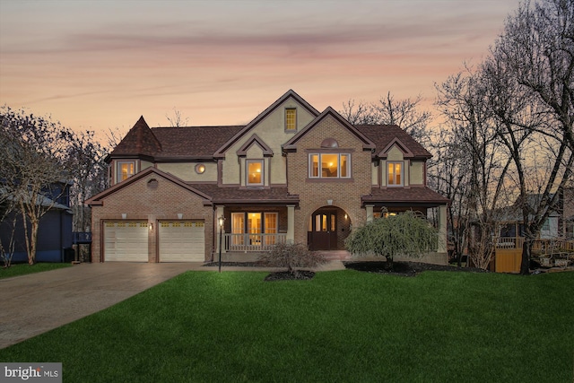 view of front facade featuring a porch, a yard, concrete driveway, a garage, and brick siding