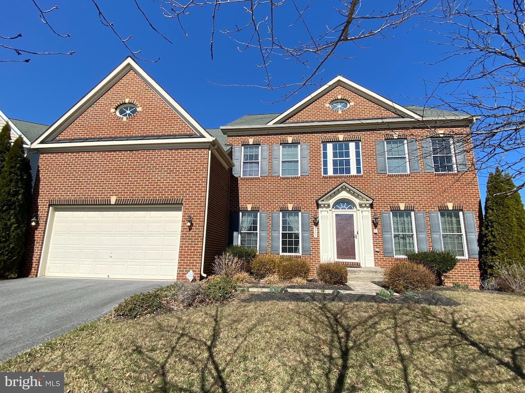 view of front facade with aphalt driveway, a garage, and brick siding