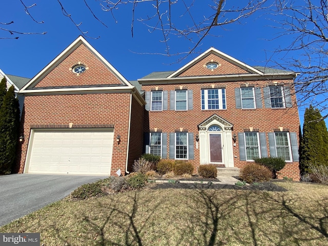 view of front facade with aphalt driveway, a garage, and brick siding