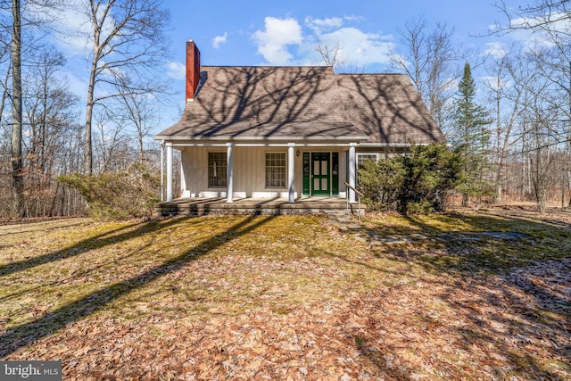 view of front of house with covered porch and a chimney