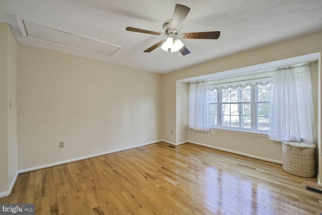 empty room with attic access, hardwood / wood-style flooring, and visible vents