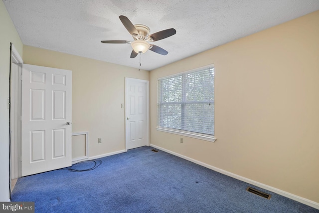 unfurnished bedroom featuring baseboards, visible vents, carpet floors, and a textured ceiling