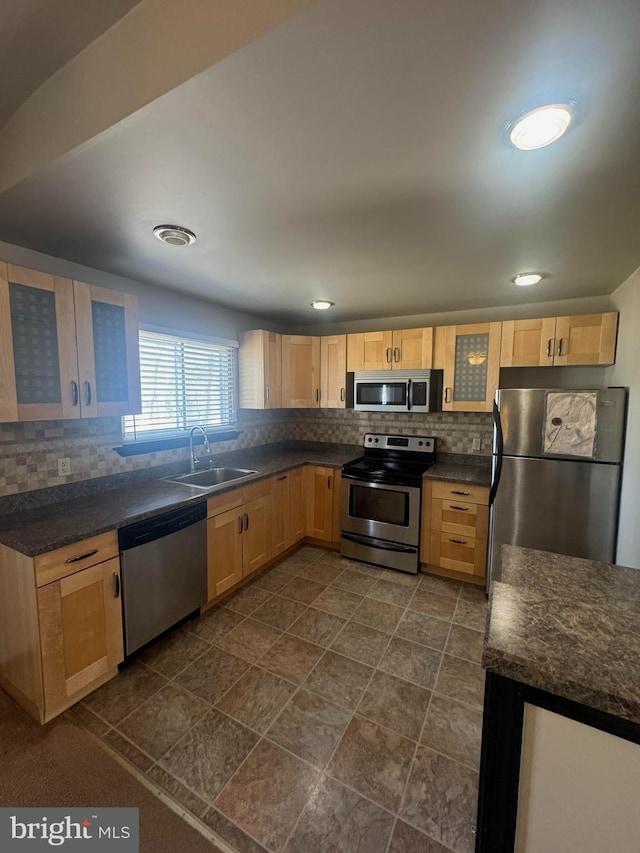 kitchen featuring a sink, tasteful backsplash, appliances with stainless steel finishes, and light brown cabinets