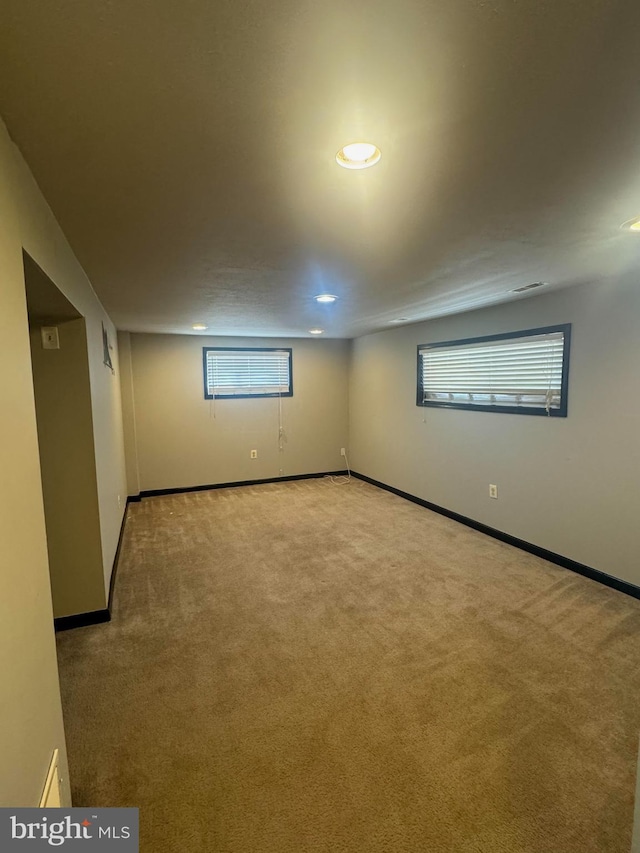 below grade area featuring carpet flooring, recessed lighting, visible vents, and baseboards