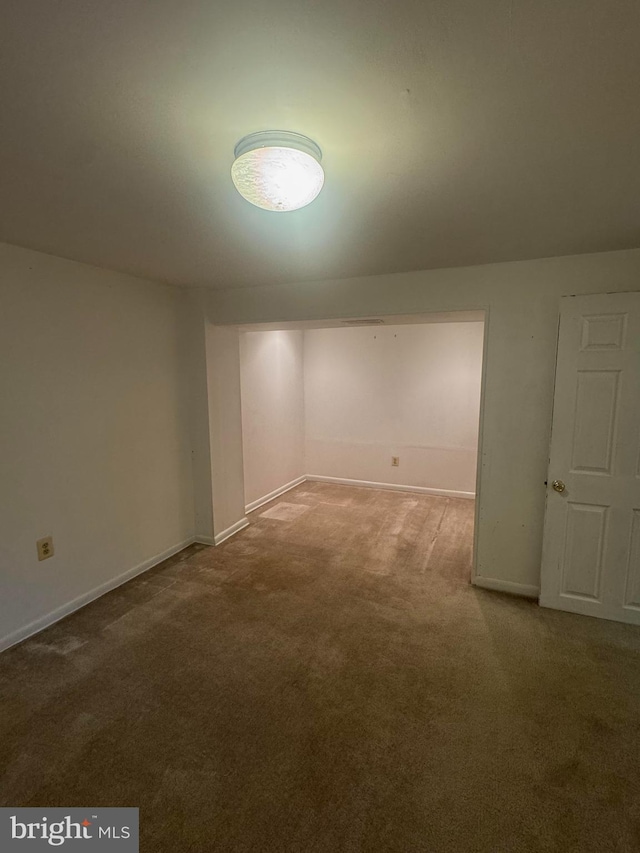 unfurnished room with baseboards and carpet floors