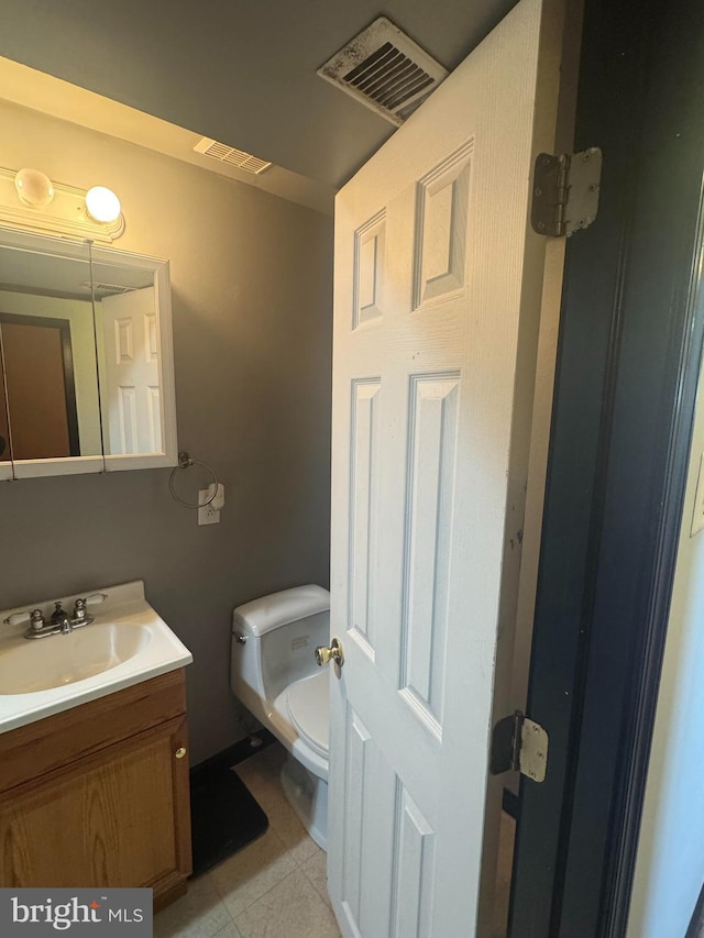 bathroom with vanity, tile patterned floors, toilet, and visible vents