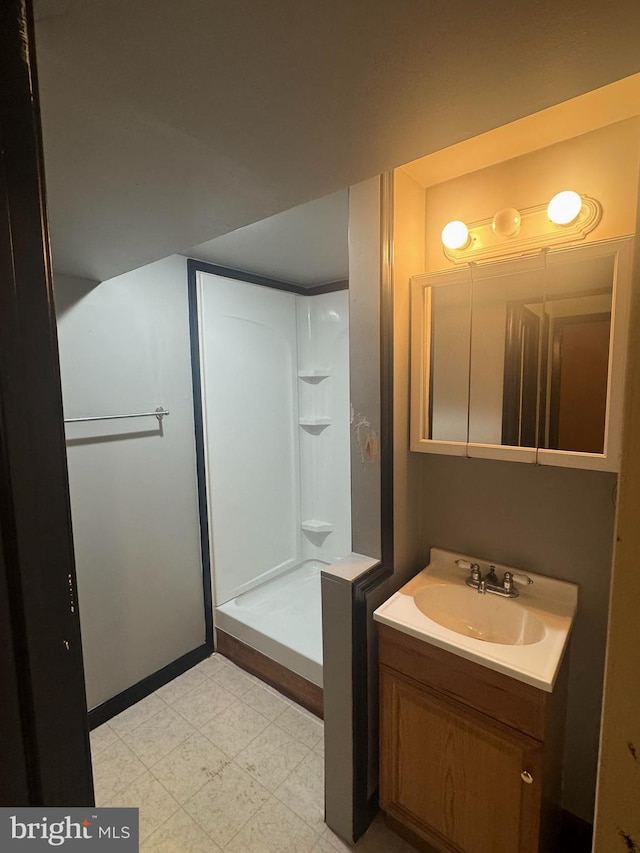 bathroom with tile patterned floors, vanity, and a walk in shower