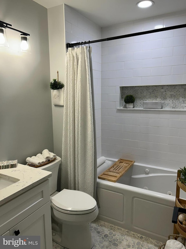 bathroom featuring vanity, toilet, and a combined bath / shower with jetted tub