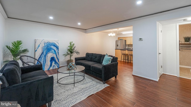 living area with wood finished floors, baseboards, an inviting chandelier, recessed lighting, and crown molding