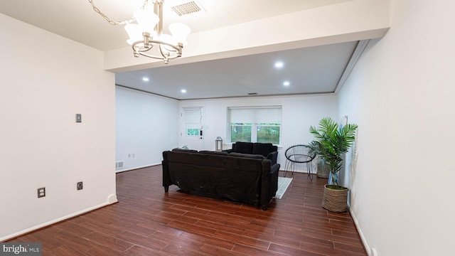 living area featuring dark wood finished floors, visible vents, a chandelier, and baseboards