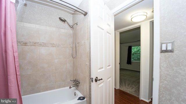 bathroom featuring wood finished floors and shower / bath combo