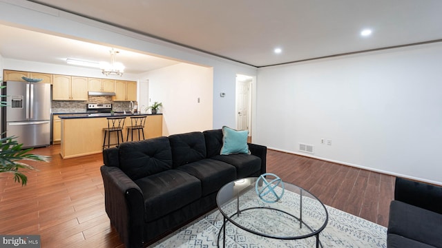 living area with visible vents, recessed lighting, an inviting chandelier, and wood finished floors