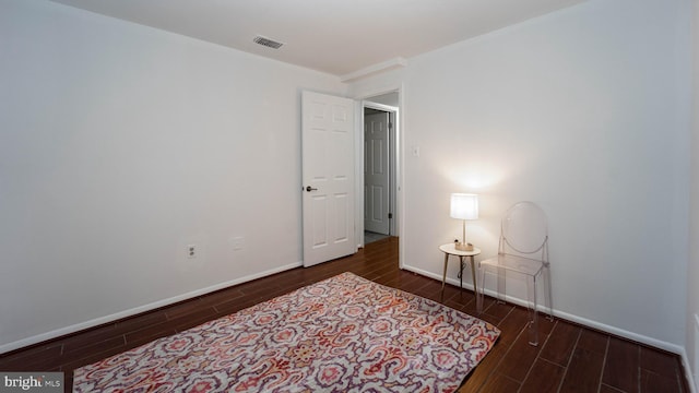 bedroom featuring baseboards, visible vents, and wood finish floors