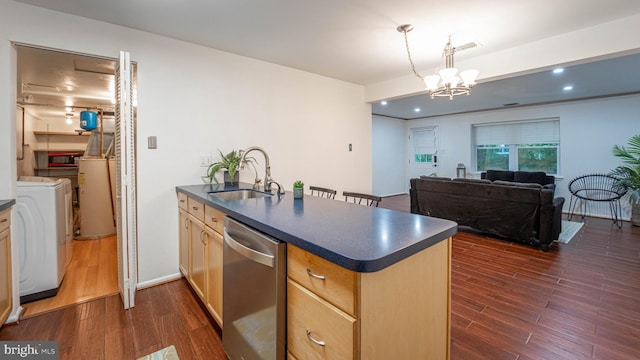 kitchen with dark countertops, dishwasher, a peninsula, washer / clothes dryer, and a sink