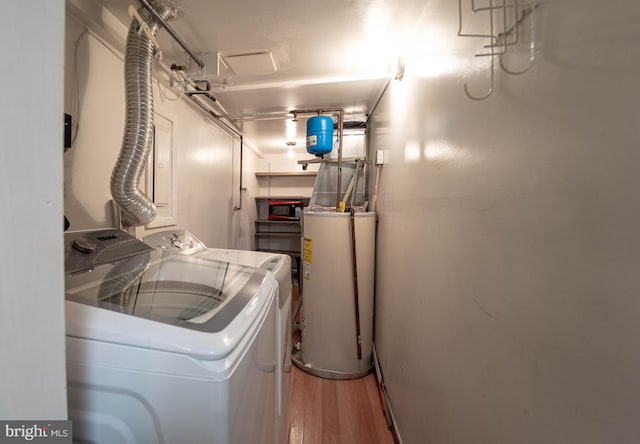 clothes washing area featuring gas water heater, wood finished floors, laundry area, and washing machine and clothes dryer