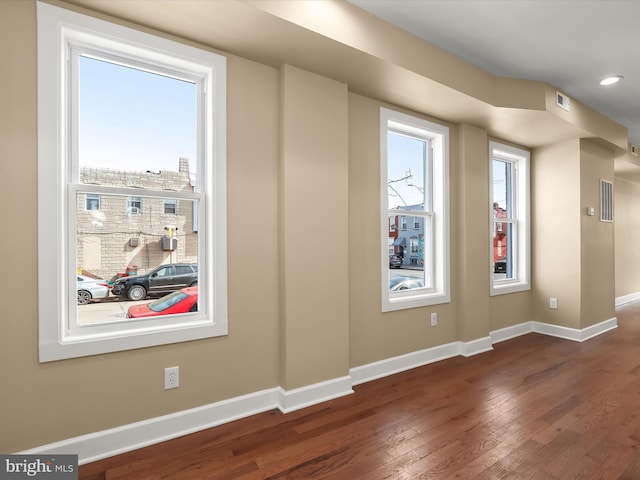 bonus room with visible vents, dark wood-style floors, baseboards, and a healthy amount of sunlight