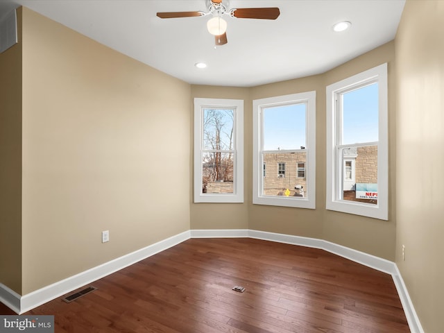 empty room featuring a ceiling fan, baseboards, visible vents, recessed lighting, and dark wood-style flooring