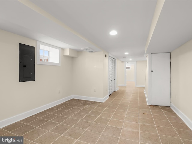 below grade area featuring electric panel, recessed lighting, baseboards, and light tile patterned floors