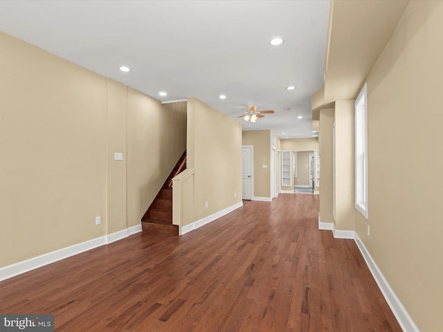 unfurnished living room featuring wood finished floors, recessed lighting, baseboards, ceiling fan, and stairs