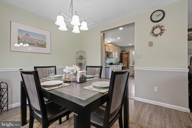 dining room featuring a chandelier, recessed lighting, baseboards, and light wood-style floors