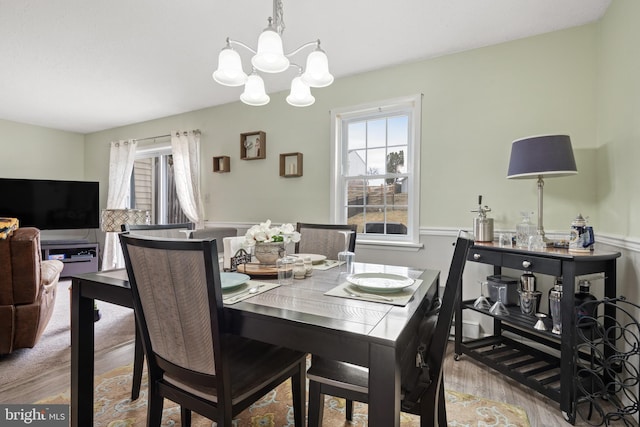 dining space featuring wood finished floors and a chandelier