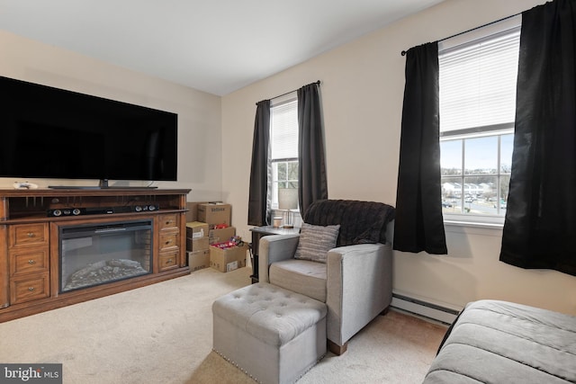 living room with light carpet, plenty of natural light, a baseboard heating unit, and a glass covered fireplace