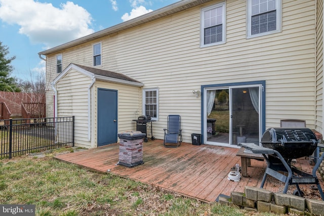 rear view of property with a deck and fence