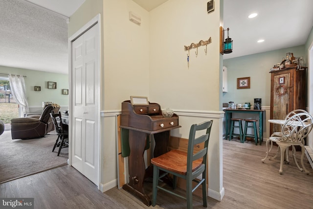 interior space featuring recessed lighting, a textured ceiling, baseboards, and wood finished floors