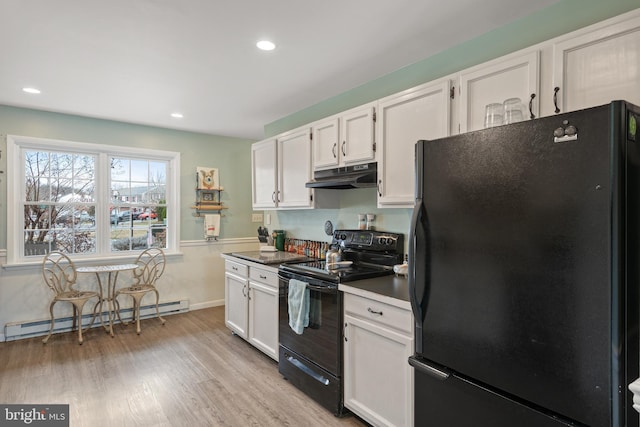 kitchen with under cabinet range hood, white cabinetry, black appliances, and a baseboard radiator