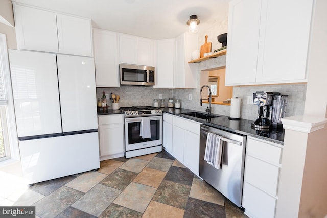 kitchen featuring a sink, stainless steel appliances, tasteful backsplash, and white cabinets