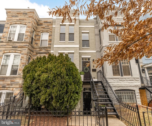 townhome / multi-family property featuring stairs and fence