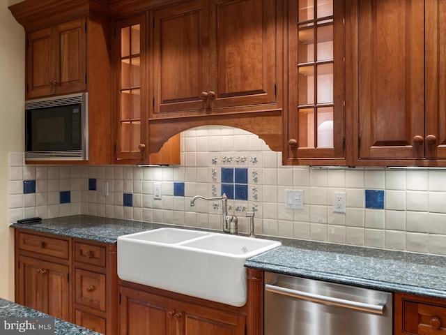 kitchen with a sink, glass insert cabinets, dishwasher, and black microwave